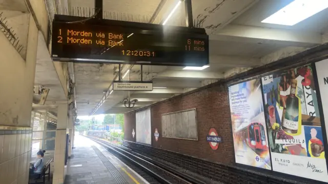 A sign on East Finchley Tube platform shows that a Morden via Bank train will arrive in six minutes and that a second train will arrive in 11 minutes