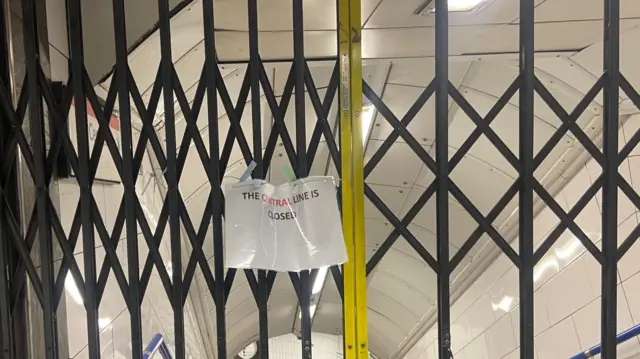 A laminated sign is tied to some gates at Oxford Circus station. A sign says that 'the central line is closed'