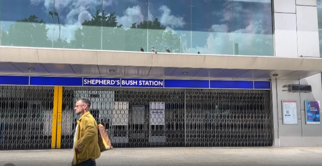 A man walks past an empty Shepards Bush Station, which has the shutters close