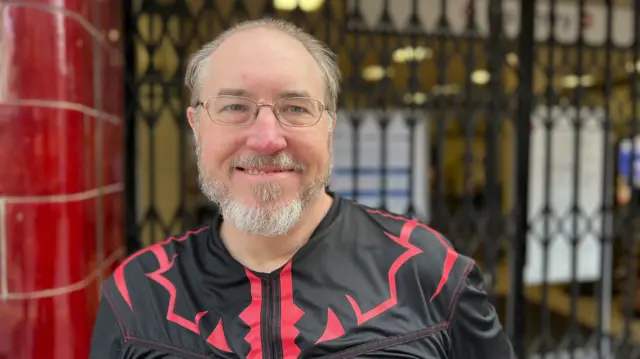 Man with beard and glasses smiles