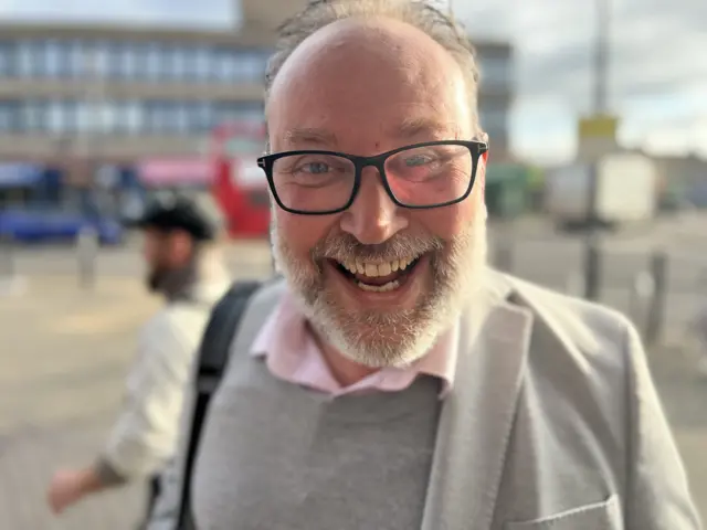 Smiling man with beard and glasses