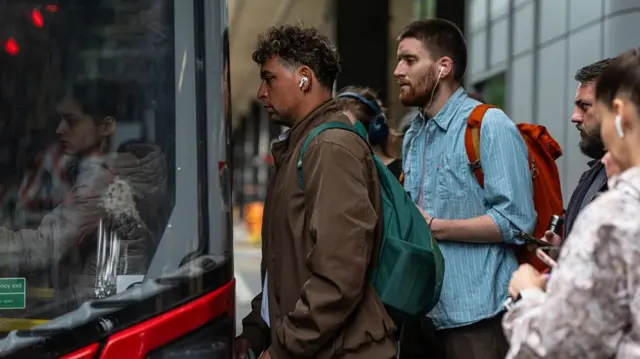 Commuters board a bus at Euston Station