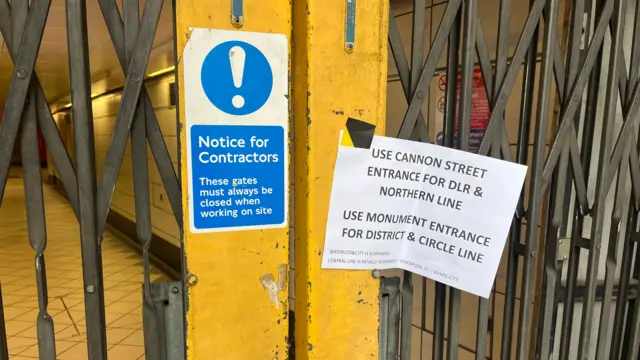 Closed shutters at Bank station, with a sign taped to them offering travel advice