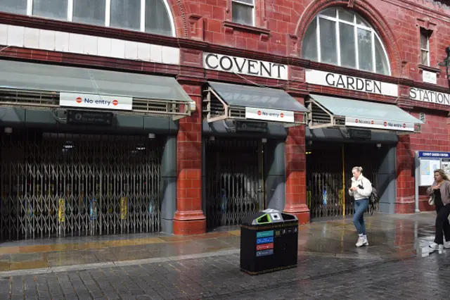 Two women walk past a closed Covent Garden station during the Tube strikes