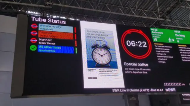 A display screen at Waterloo Station shows Tube cancellations and delays.