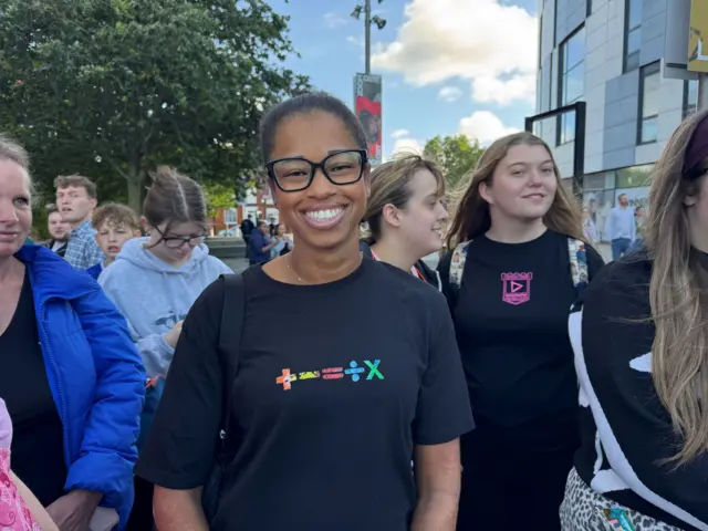 Ashanti Coleman wearing an Ed Sheeran T-shirt, smiling