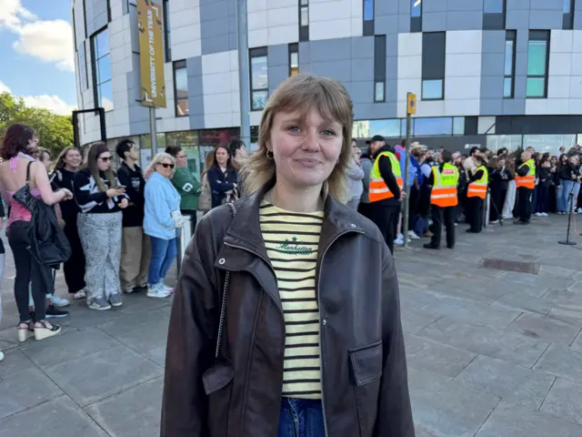 A woman wearing a striped T-shirt and jacket