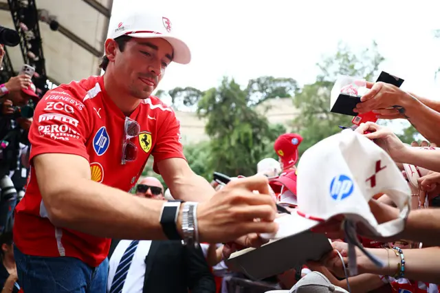 Charles Leclerc signs autographs in the Moanco paddock