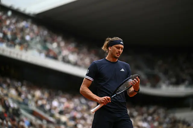 Alexander Zverev checks his racket