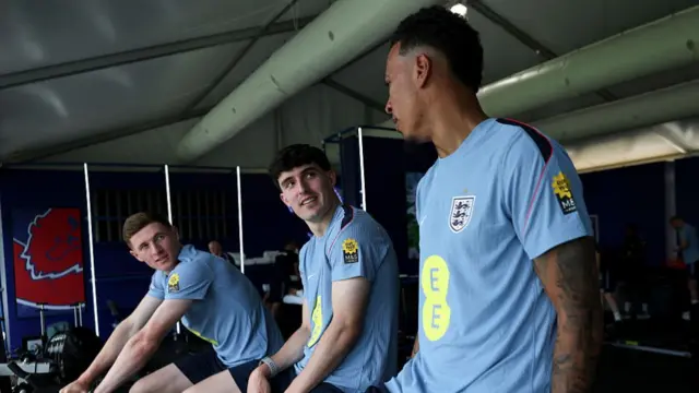 Elliot Anderson, Tino Livramento and Morgan Rogers of England work out in the gym on exercise bikes