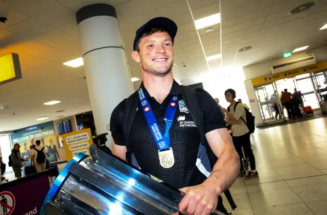 George Horne celebrates with the URC trophy in the airport