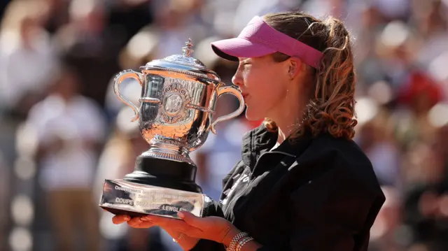 Mirra Andreeva kisses the French Open women's singles trophy