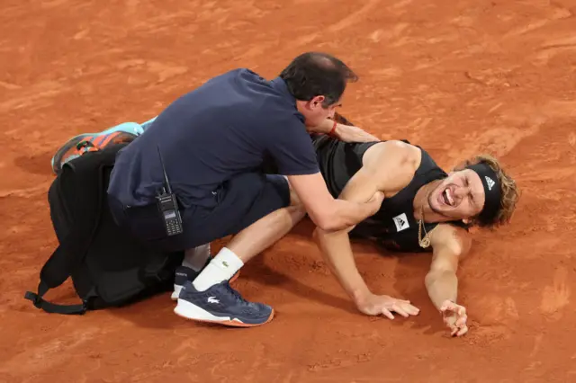 Alexander Zverev (aka Sascha Zverev) of Germany receives medical attention following an injury against Rafael Nadal