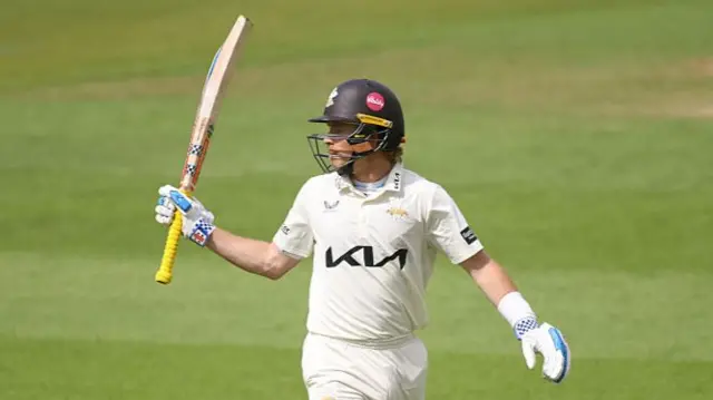 Ollie Pope raises his bat for his half-century