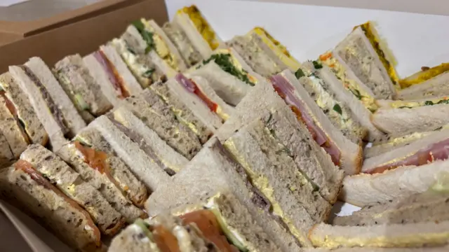 Sandwiches on a table with different types of bread and different fillings.