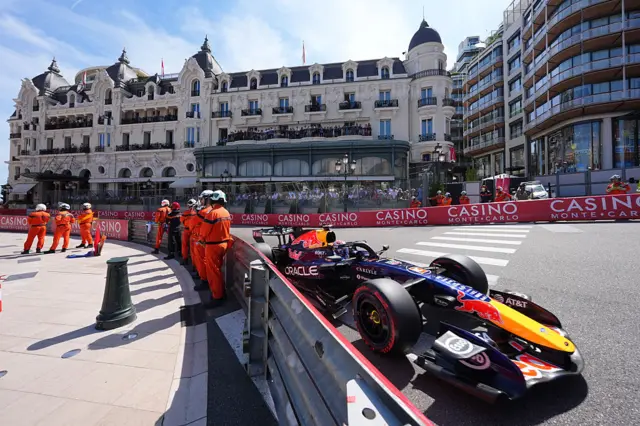 Max Verstappen drives past marshals standing at the side of the track in Monaco