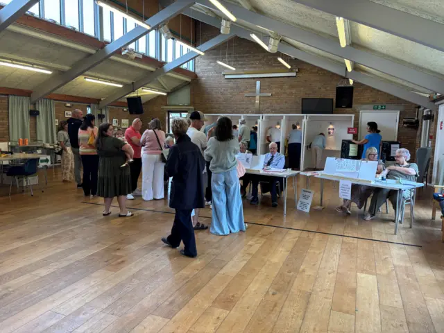 People queueing inside a polling station