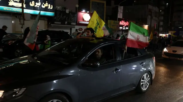 Pro-government Iranian demonstrators wave flags of Iran and Lebanon's Hezbollah movement.