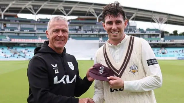 Alec Stewart presents Dan Lawrence with his Surrey cap during the tea interval