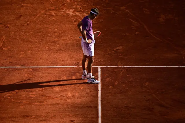 Italy's Flavio Cobolli examines a ball mark