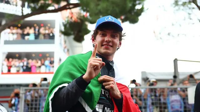 Kimi Antonelli with the Italian flag wrapped around him