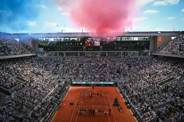 Smoke in the colours of the French flag are seen over Court Philippe-Chatrier during the ceremony ahead of the men's final singles match