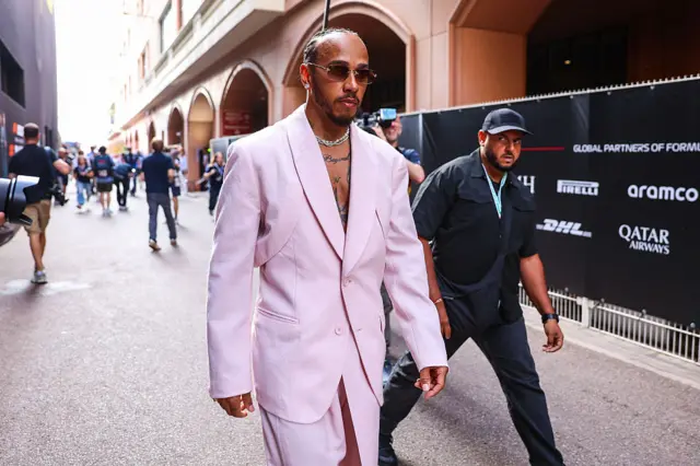 Lewis Hamilton arrives in the Monaco paddock in a lilac suit