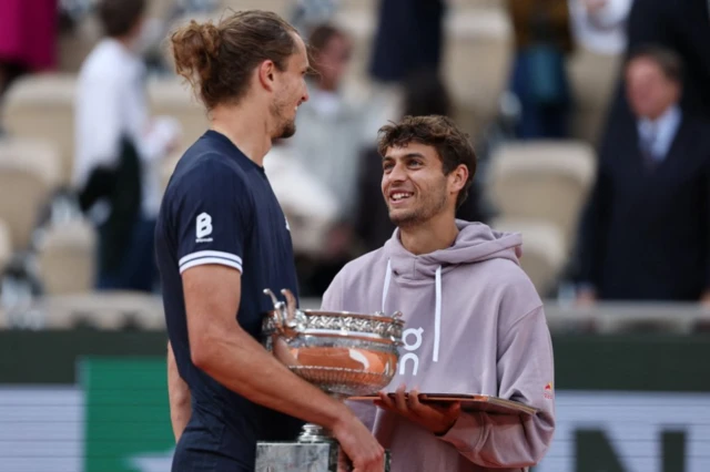 Germany's Alexander Zverev holds the trophy as he speaks with Italy's Flavio Cobolli