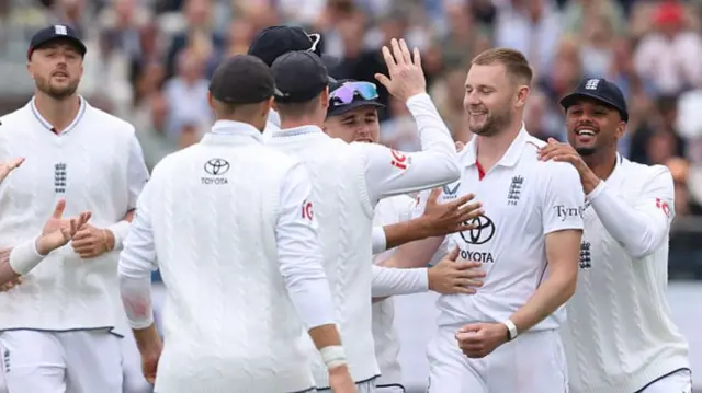 Gus Atkinson is mobbed by England players after his 5-30
