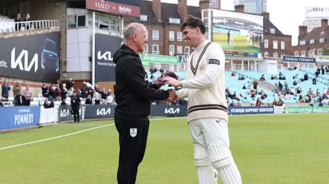 Alec Stewart hands Dan Lawrence his Surrey cap