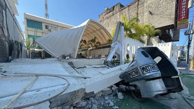 A collapsed building crushes a motor taxi after an earthquake in the southern Philippines