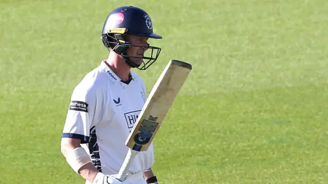 Nick Gubbins celebrates his 50 by raising his bat