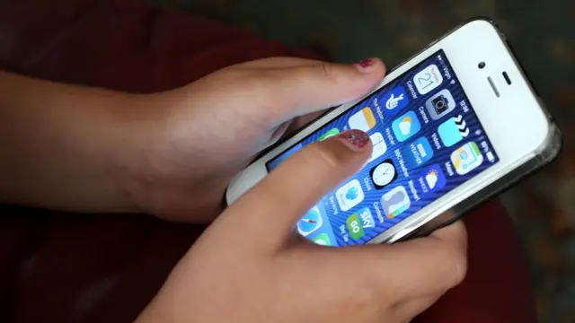 Hands holding a white iPhone.
