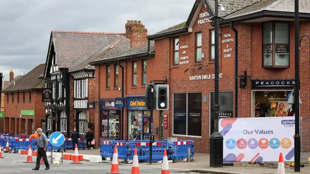 People walk along Ashton-in-Makerfield high street