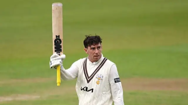 Dan Lawrence raises his bat after passing 200