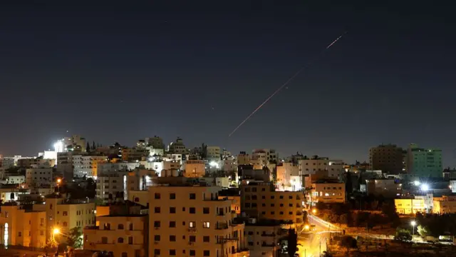Missiles launched from Iran toward Israel are seen in the sky over the West Bank city of Hebron on June 7, 2026.