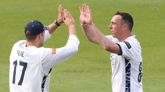 Kyle Abbott celebrates a late wicket on day one against Surrey