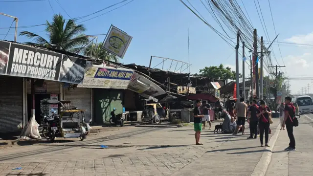 People gathering around collapsed shopfronts