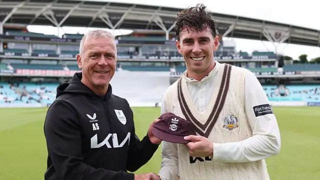Director of cricket Alec Stewart hands Dan Lawrence his Surrey cap