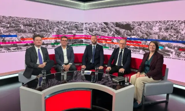 Men and women in suits on sofa