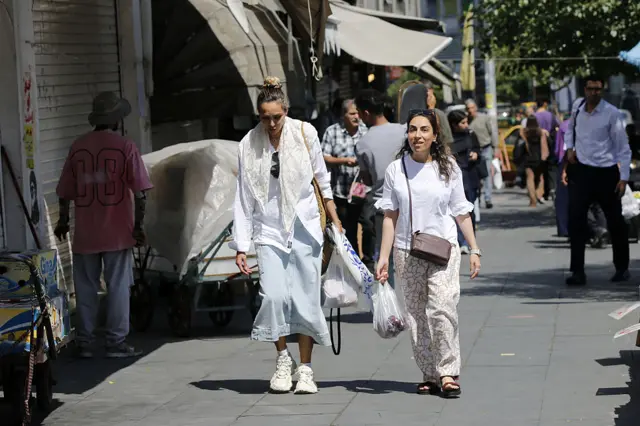 Woman walking down the street holding shopping