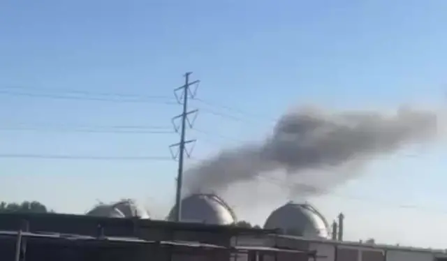 A still from a video showing a cloud of smoke rising over a petrochemical plant