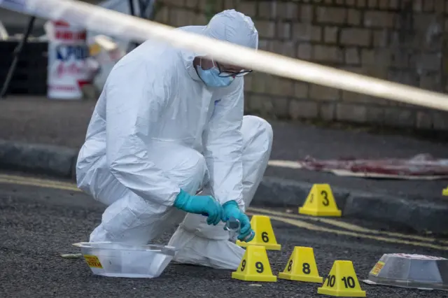 Police officers remain at the scene of a serious stabbing incident on Kinnaird Avenue in north Belfast.