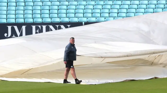 Lee Fortis removes covers at the Oval on day two