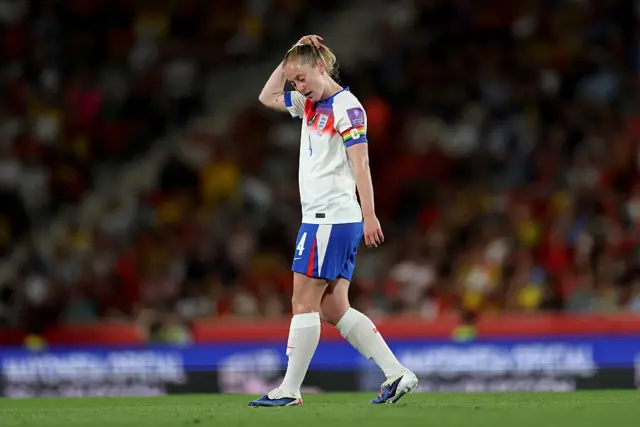 Keira Walsh with her hand on her head in an England home kit