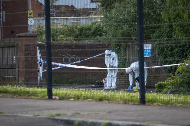Police officers remain at the scene of a serious stabbing incident on Kinnaird Avenue in north Belfast.