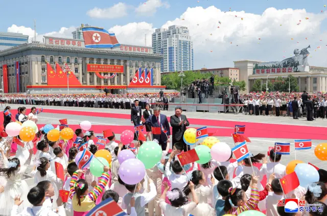 Chinese President Xi Jinping walks with North Korean leader Kim Jong Un during a welcoming ceremony