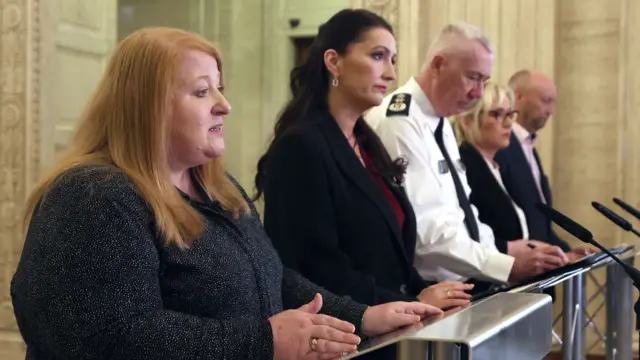 A woman with red hair, woman with black hair, man with white hair, woman with blonde hair and man with beard