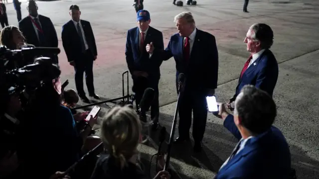 Donald Trump speaking to members of the media at JFK International Airport.