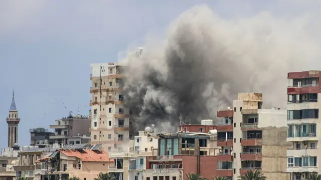 Smoke billows out of mid and high rise buildings in a city in Lebanon